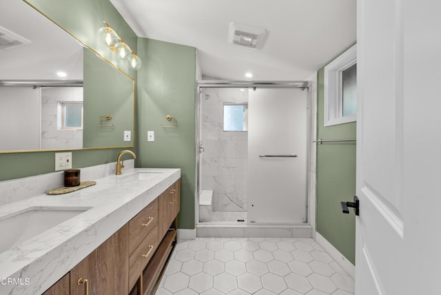 full bath featuring baseboards, double vanity, a sink, and a shower stall