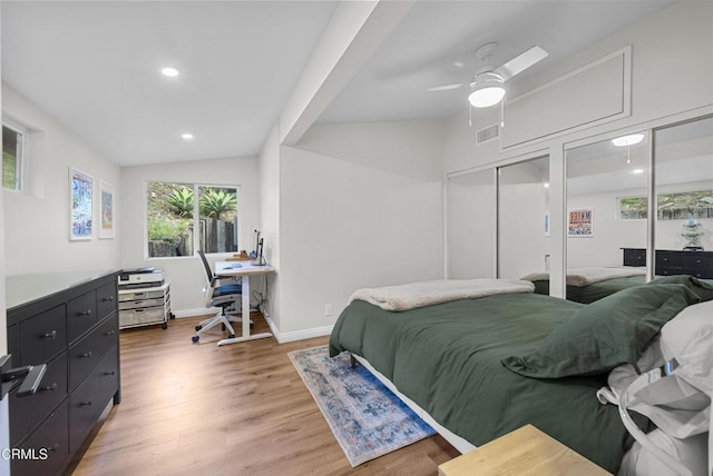 bedroom with light wood finished floors, two closets, recessed lighting, visible vents, and vaulted ceiling