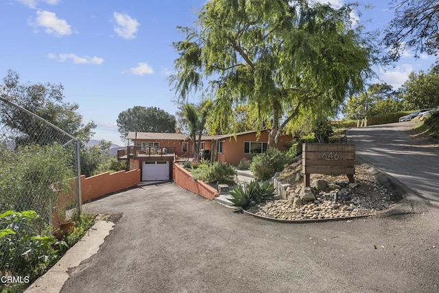 view of front of property with a garage, driveway, and fence