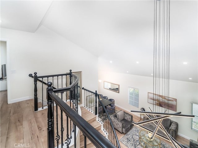 hall with light wood finished floors, recessed lighting, baseboards, and an upstairs landing