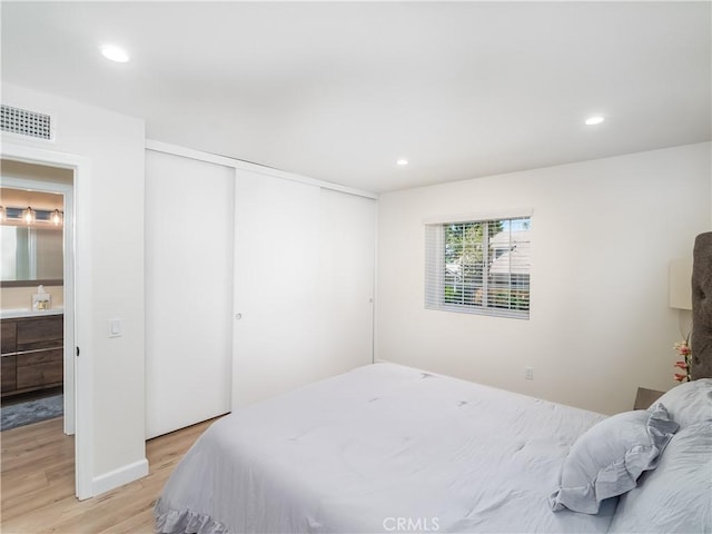 bedroom with recessed lighting, a closet, visible vents, and light wood finished floors