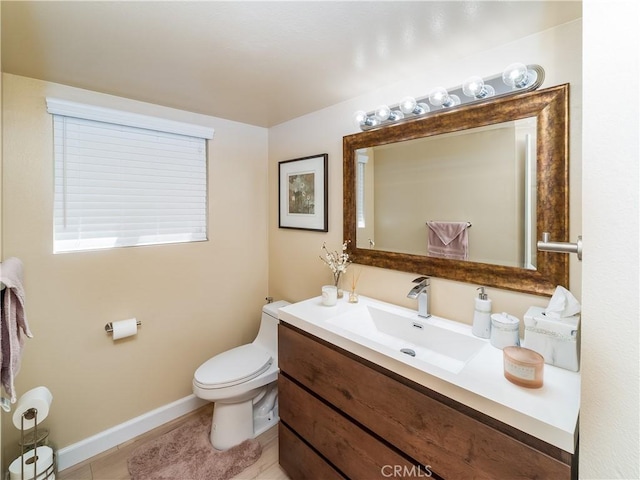 half bath with tile patterned flooring, vanity, toilet, and baseboards