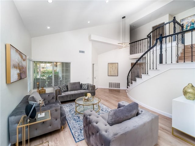 living room featuring stairs, visible vents, and wood finished floors