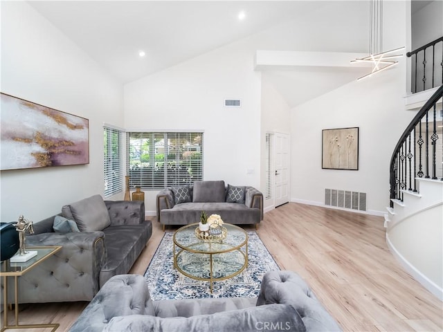 living area featuring stairs, wood finished floors, visible vents, and baseboards