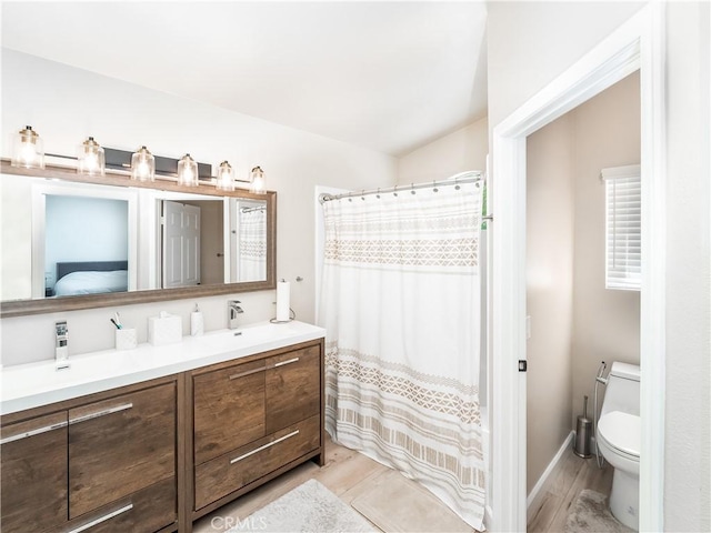 full bath featuring vanity, wood finished floors, toilet, and baseboards