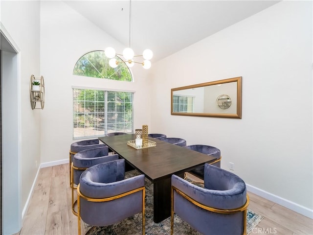 dining space featuring lofted ceiling, a notable chandelier, baseboards, and wood finished floors