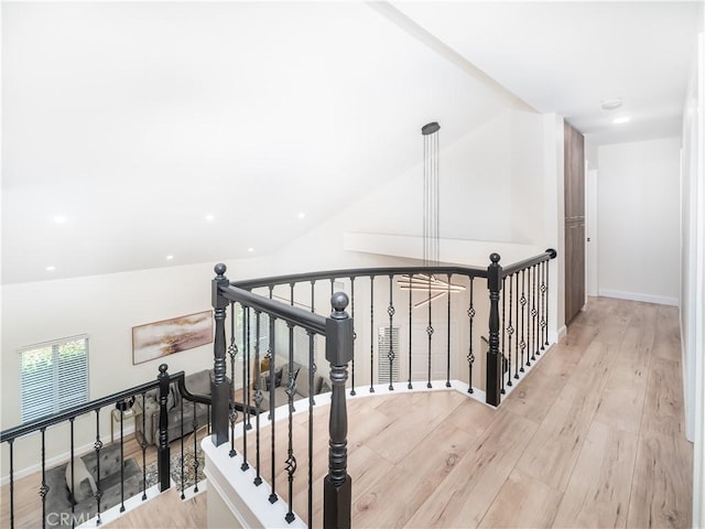 interior space with baseboards, vaulted ceiling, and wood finished floors