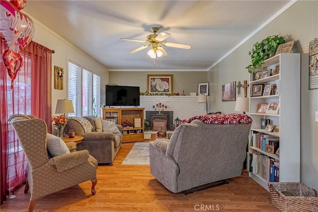 living area featuring light wood-type flooring, crown molding, and ceiling fan