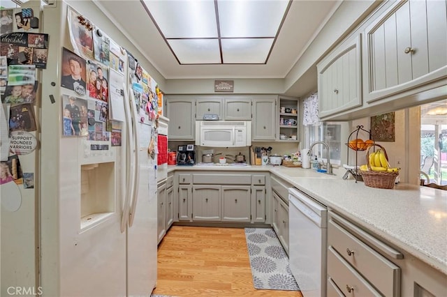 kitchen with white appliances, a sink, light countertops, light wood-type flooring, and open shelves