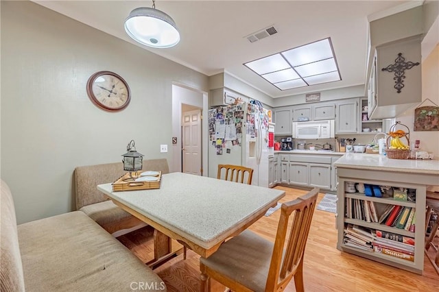 dining area featuring light wood finished floors and visible vents