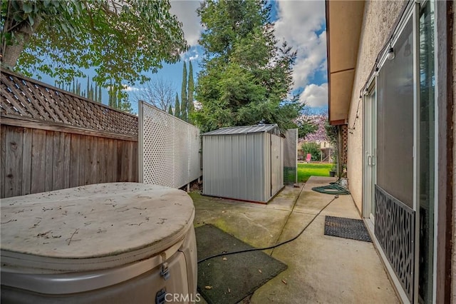 view of patio with an outbuilding, a fenced backyard, and a storage unit