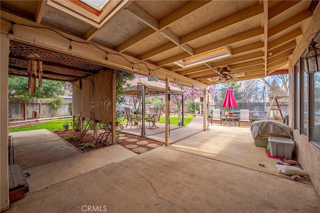 view of patio / terrace with a trampoline, outdoor dining area, and fence