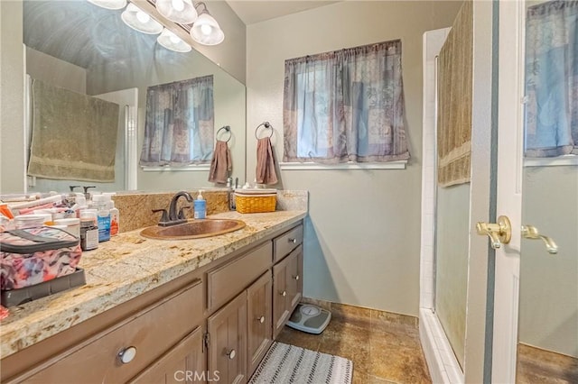 bathroom featuring vanity, baseboards, and a walk in shower