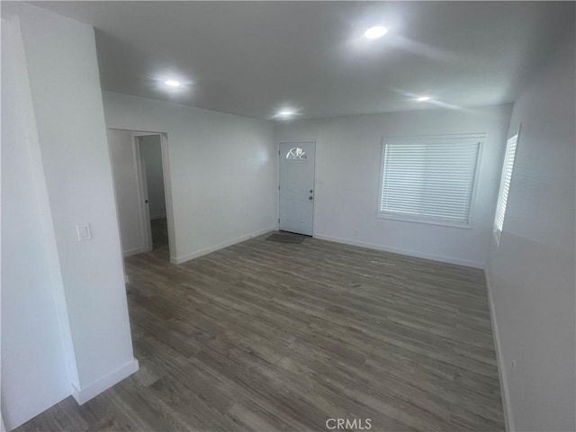 spare room with recessed lighting, dark wood-style flooring, and baseboards