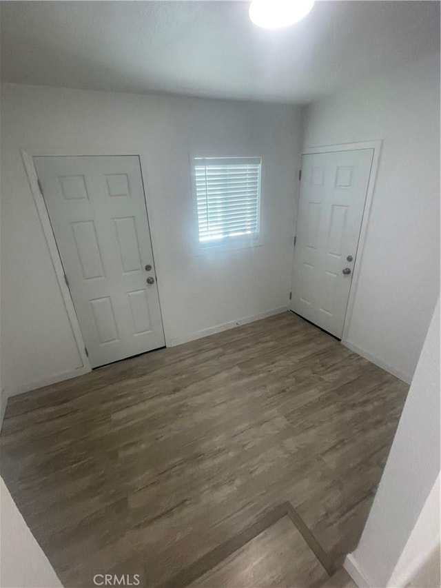 empty room with baseboards and wood finished floors