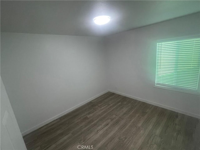 unfurnished room with dark wood-style floors and baseboards