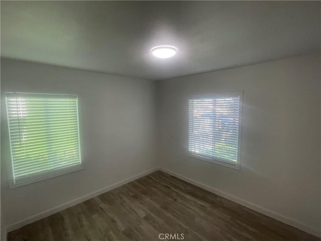 empty room featuring wood finished floors and baseboards