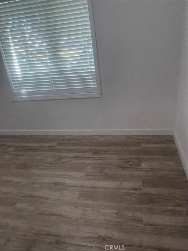 empty room featuring baseboards and wood finished floors