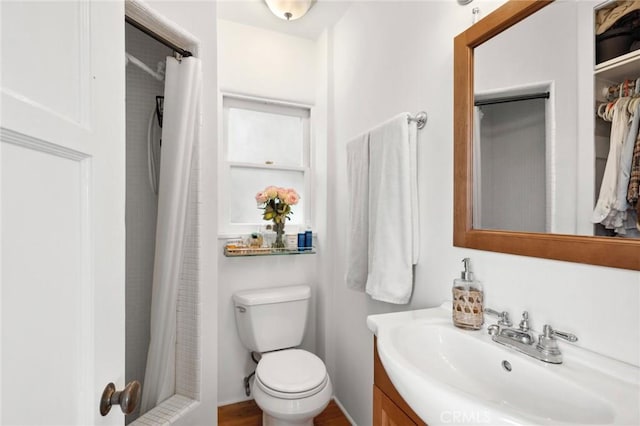 bathroom featuring a shower with curtain, vanity, and toilet