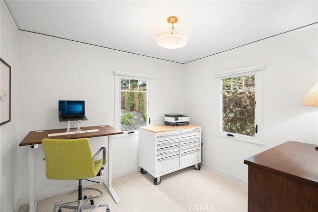 office area featuring baseboards, a wealth of natural light, and light colored carpet