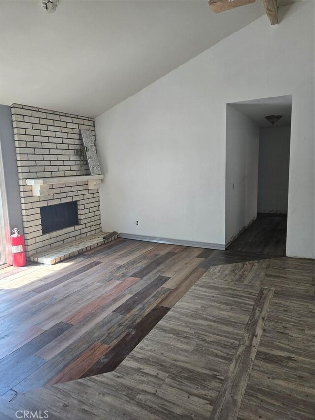 3269 Highcliff Rd, Riverside, CA 92506 - unfurnished living room featuring a brick fireplace, vaulted ceiling, and wood finished floors