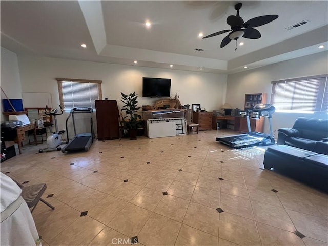 living room featuring a ceiling fan, a raised ceiling, visible vents, and recessed lighting