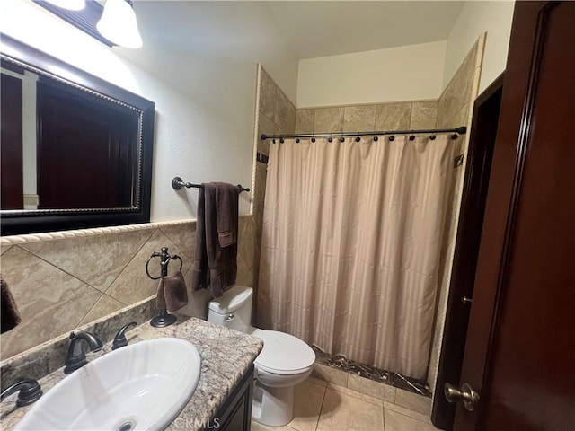 bathroom with tile walls, curtained shower, toilet, vanity, and tile patterned floors