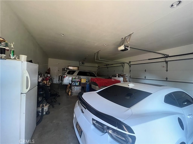 garage featuring a garage door opener and freestanding refrigerator