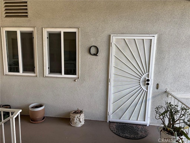 property entrance featuring stucco siding