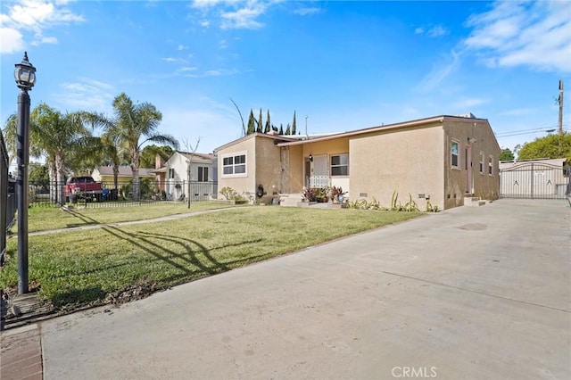 view of front facade with a front yard, fence, and stucco siding