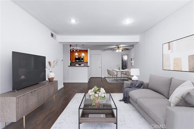 living room with ceiling fan, visible vents, dark wood finished floors, and recessed lighting