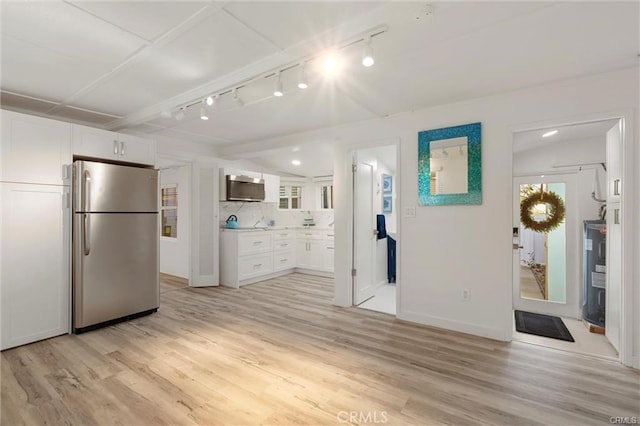 kitchen featuring a healthy amount of sunlight, light wood-style floors, white cabinets, and freestanding refrigerator