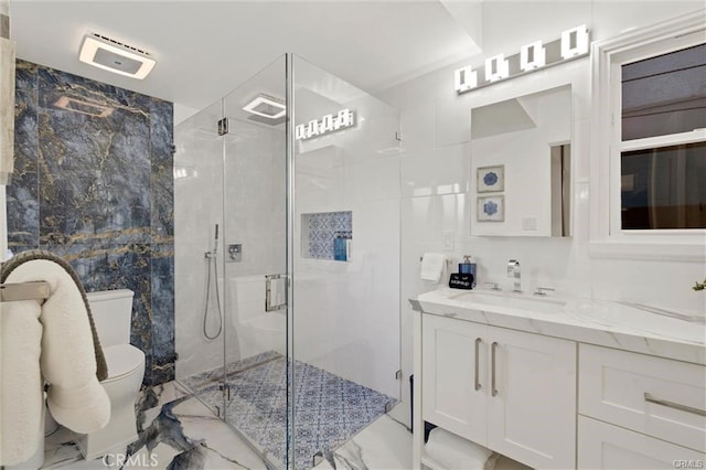 full bathroom with toilet, marble finish floor, vanity, and a stall shower