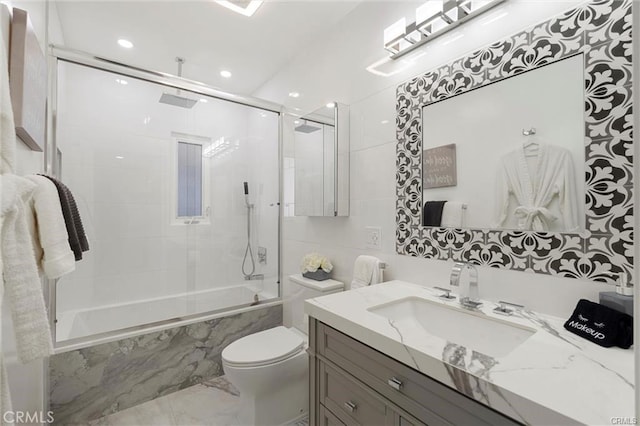 bathroom with toilet, marble finish floor, vanity, and a combined bath / shower with rainfall shower