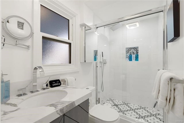 full bathroom featuring toilet, a shower stall, and vanity