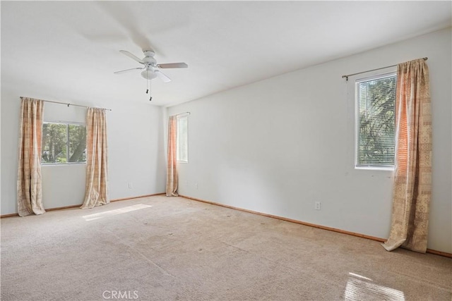 carpeted empty room with ceiling fan and baseboards