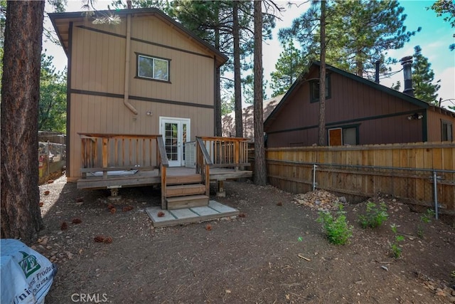 back of house featuring fence and a deck