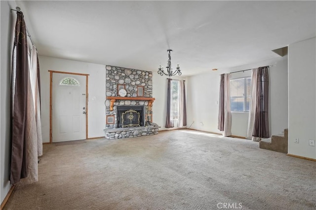 unfurnished living room featuring a chandelier, carpet, a fireplace, and stairway