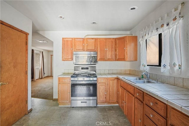 kitchen with stainless steel appliances, visible vents, a sink, and tile countertops