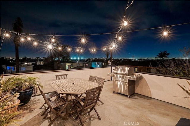 patio at twilight with outdoor dining space and area for grilling