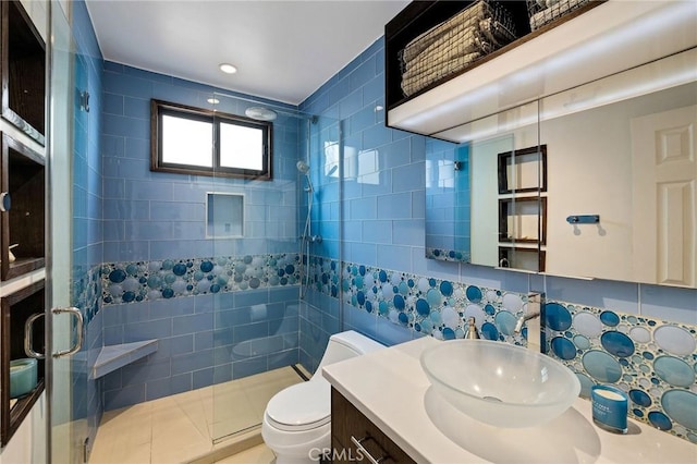 full bath featuring vanity, a shower stall, toilet, and tile walls