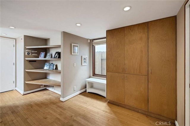 interior space with baseboards, recessed lighting, and light wood-style floors