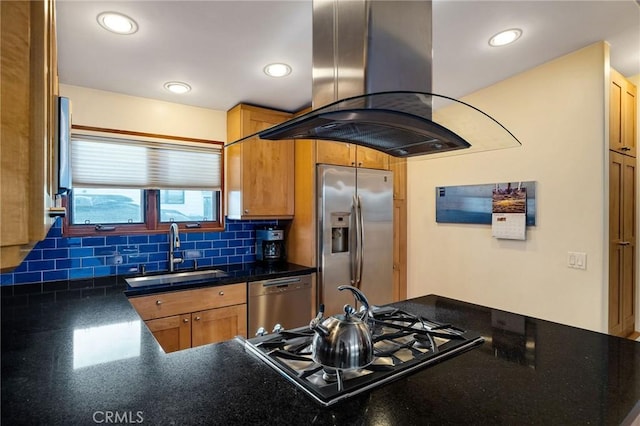 kitchen with tasteful backsplash, island range hood, dark countertops, appliances with stainless steel finishes, and a sink