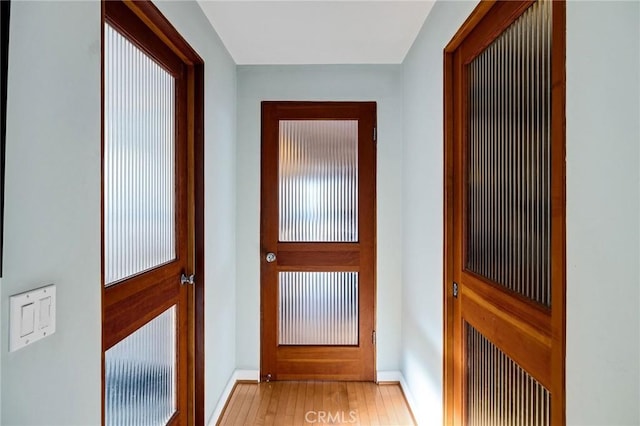 doorway featuring light wood-type flooring and baseboards