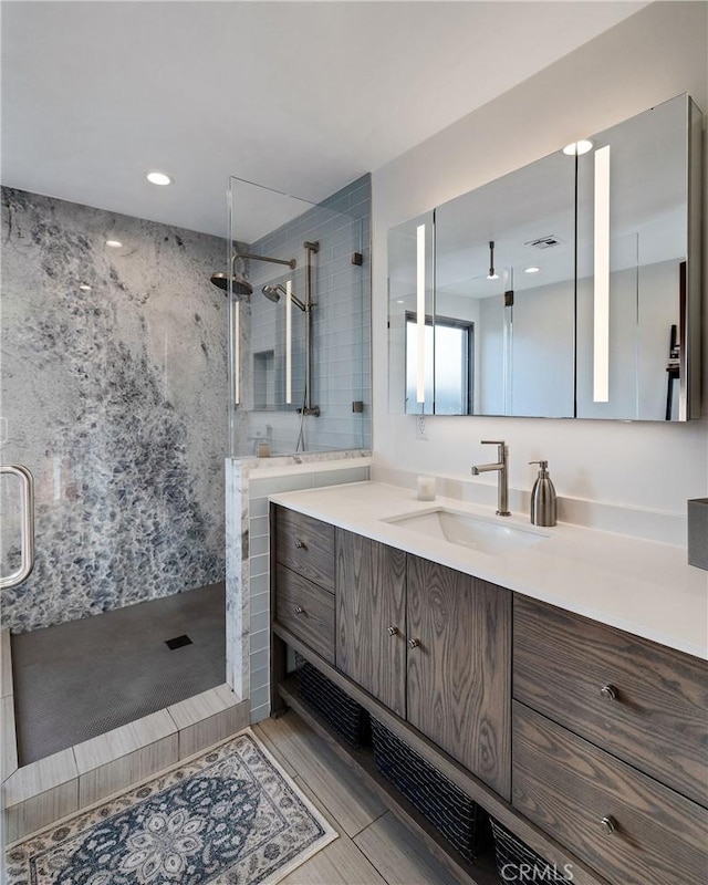 full bathroom with a stall shower and vanity