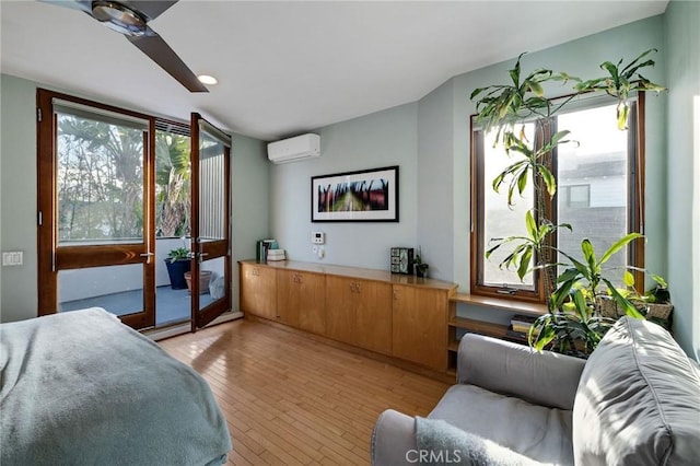 bedroom with light wood finished floors, access to outside, and a wall mounted AC