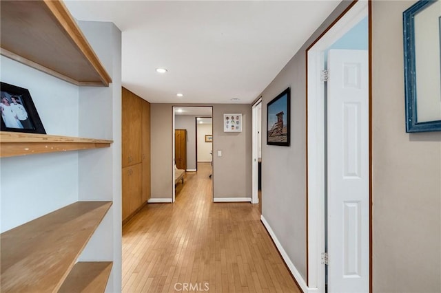 hallway featuring recessed lighting, light wood-style flooring, and baseboards