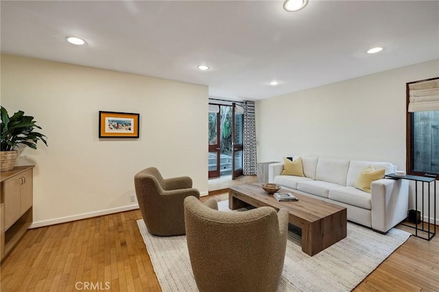 living area with light wood-style flooring, baseboards, and recessed lighting