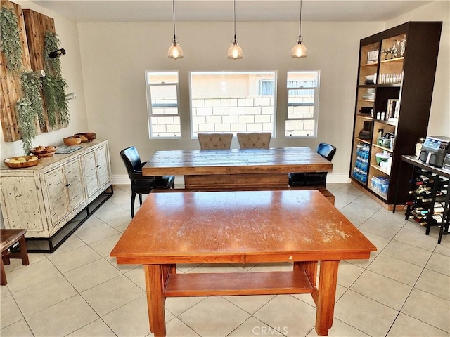 dining space featuring light tile patterned flooring and baseboards