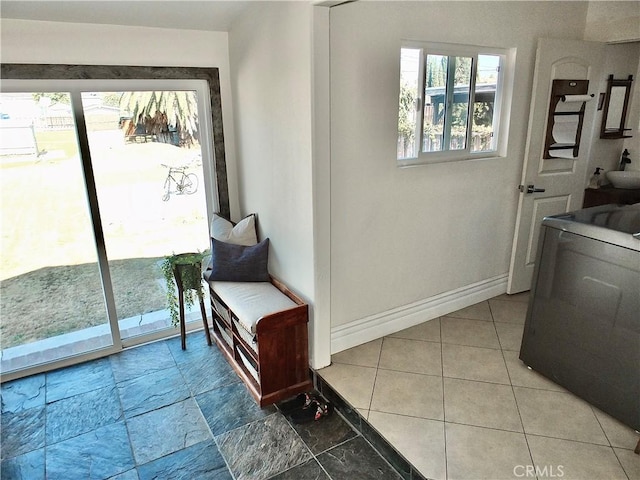 doorway to outside featuring washer / dryer and baseboards